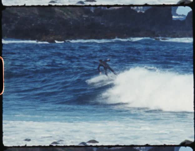 Man riding a wind wave in the ocean on a surfboard falls over and lands in the water