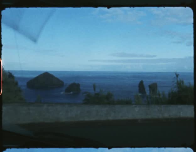 Man drives car along coastal highway on cloudy day