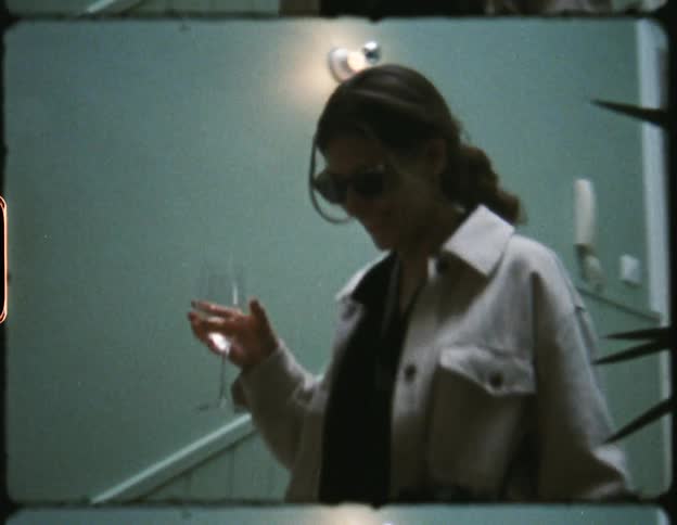 A woman walks down the stairs carrying a drink
