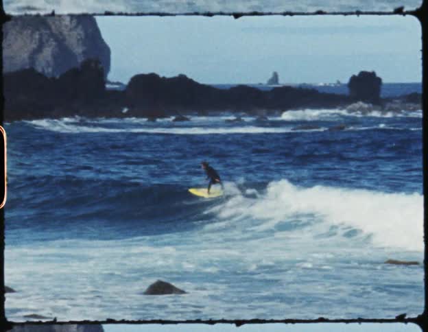 An old film strip of two people surfing in the ocean