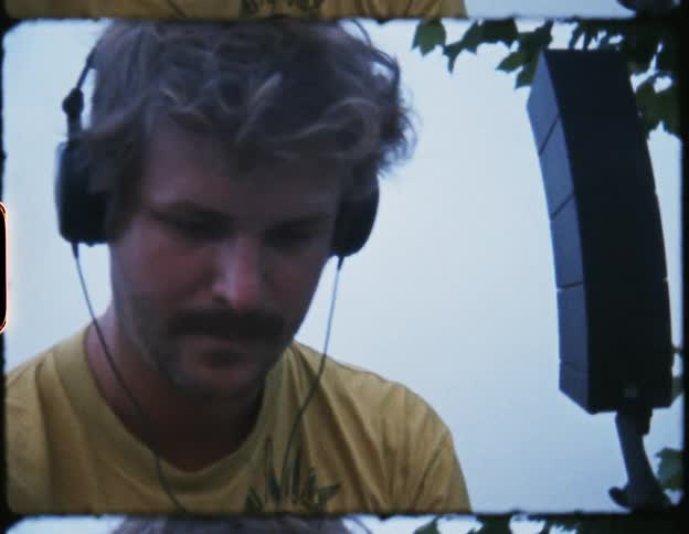 An old film strip of a man using audio equipment outside