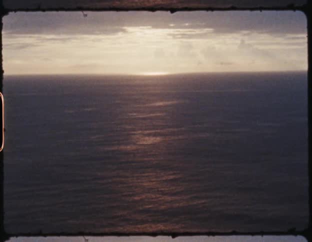 An old film of the sun setting over the ocean
