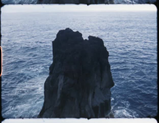A large rock formation is in the water