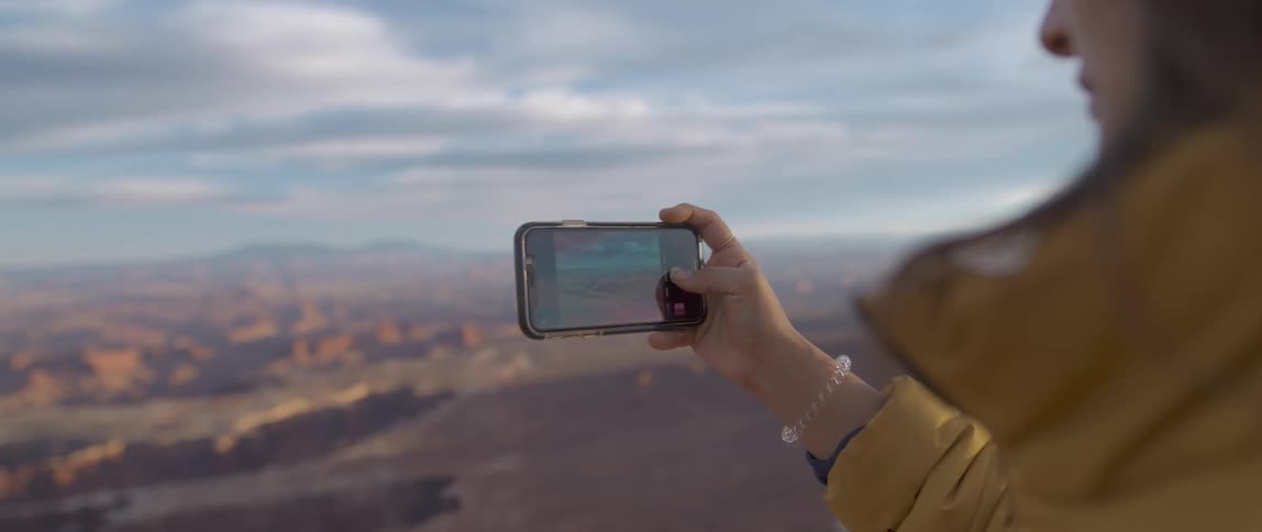 A woman is taking a photo with her cell phone