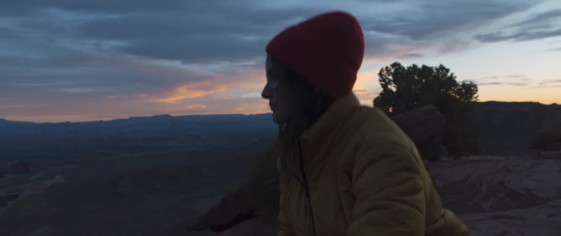 A woman is crouching outdoors and stands up