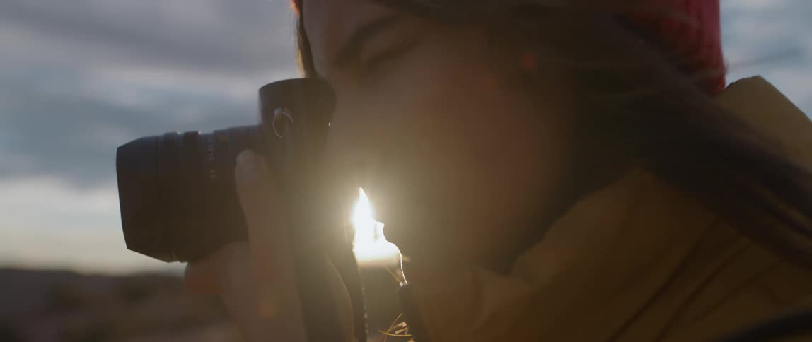 A woman is taking photos on a windy day