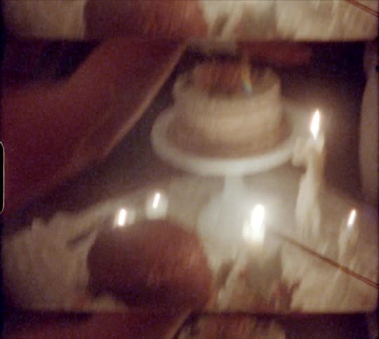 A newly wed couple laugh as the groom wipes cake off his face