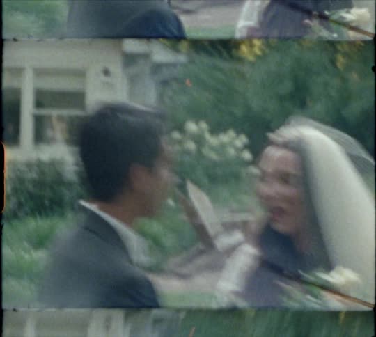 A bride and groom kiss in the yard