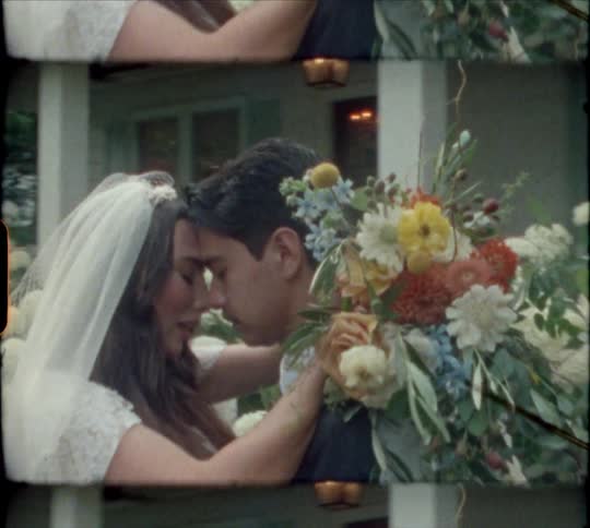 Bride holding a bouquet of flowers hugs a groom and he kisses her