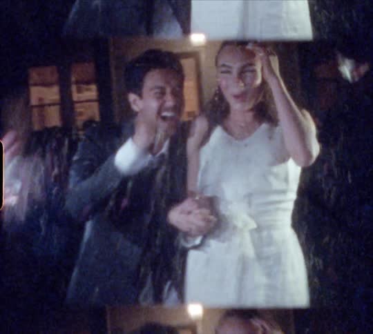 People throw rice at bride and groom at night near house