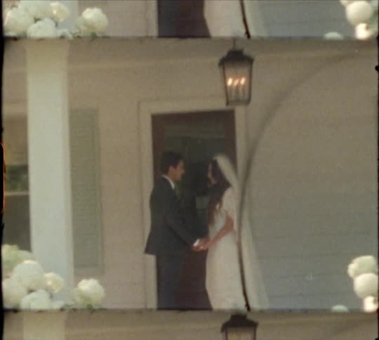 Married couple kisses on porch in next to front door