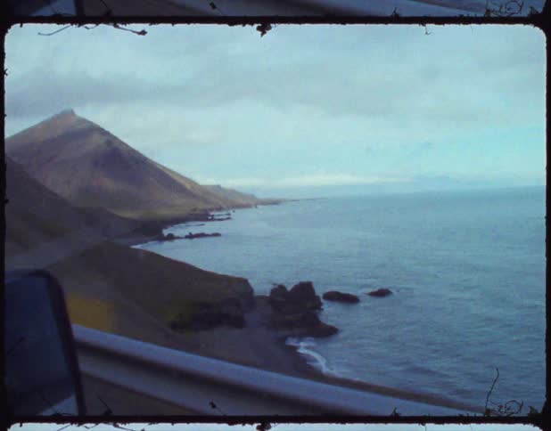 Vehicle driving on a mountain road in the coast near the ocean on film