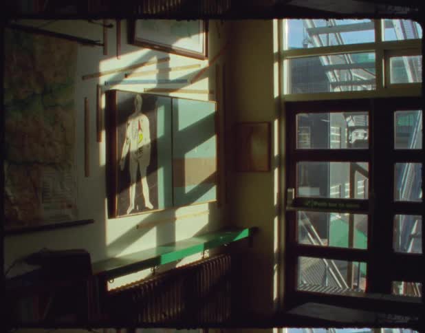 Stairs show through glass paneled door near figure diagram hanging on wall
