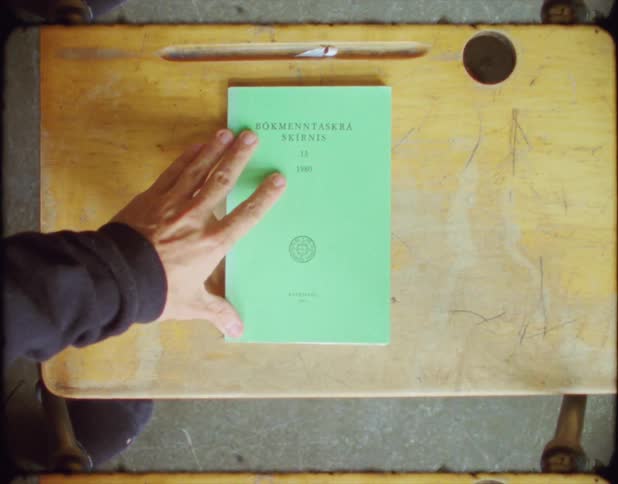 A person placing a book on a desk