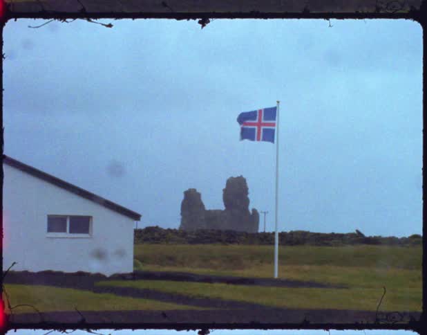 A flag flies on a flag pole in the wind