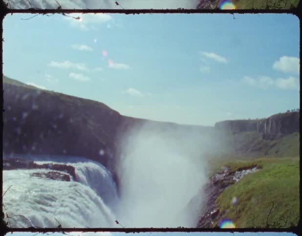 A river rushes over a cliff to create and enormous and powerful waterfall