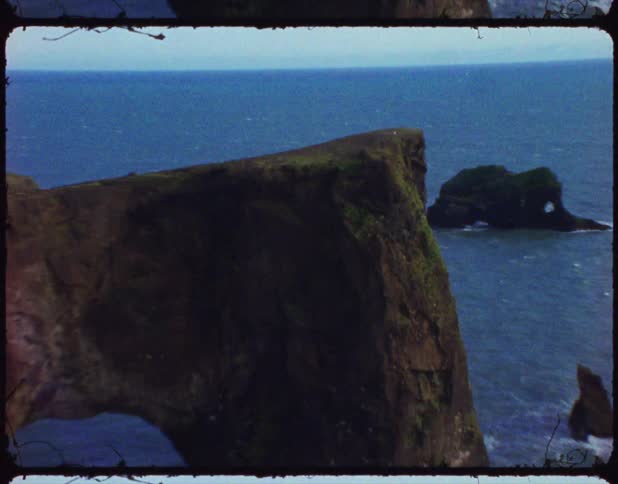 Ocean passes through opening in vegetation covered cliff