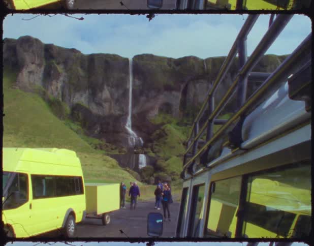 A filmstrip of people standing outside vans parked at a waterfall