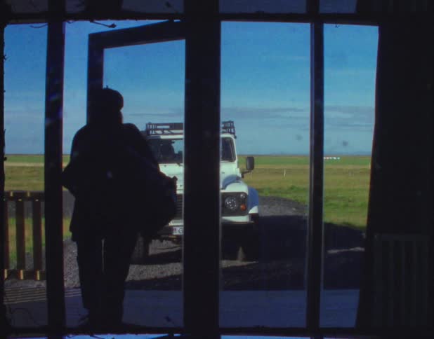 A woman walks out a door towards a vehicle