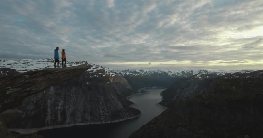 Two people are standing in the lip of a cliff