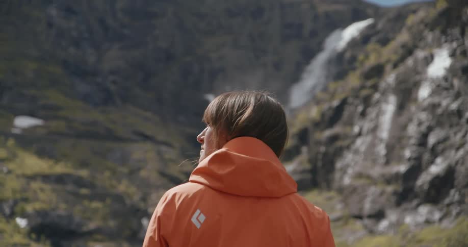 A woman is looking over at a mountain range on a sunny day