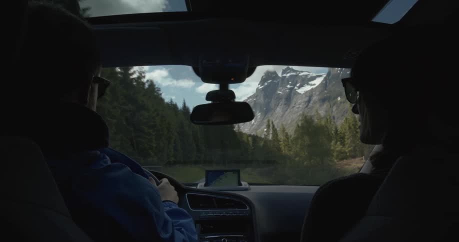 A man talks with a woman as he drives