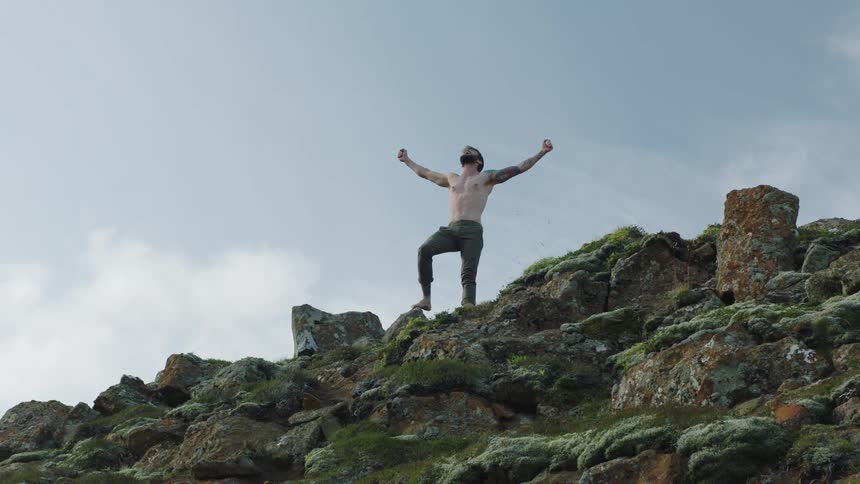 A man is standing outdoors on a mountain