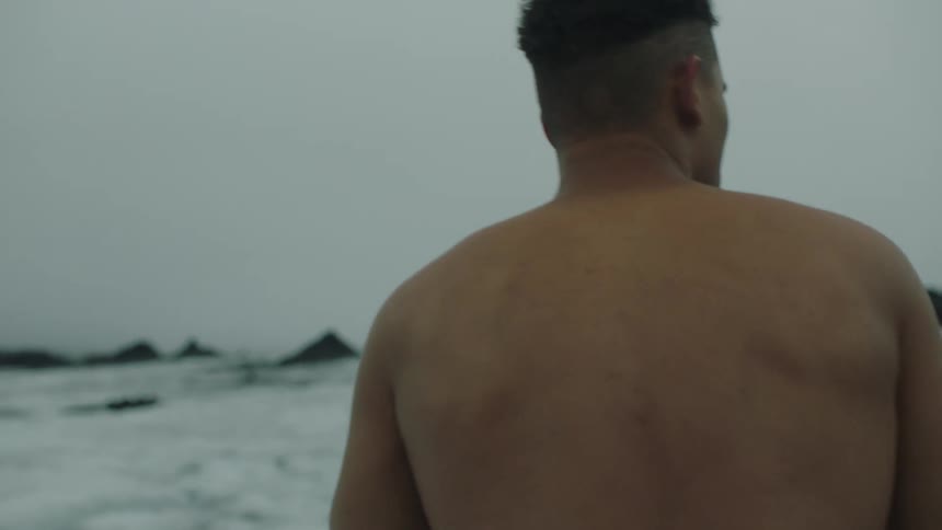 Shirtless muscular young man walking on the ice covered plains