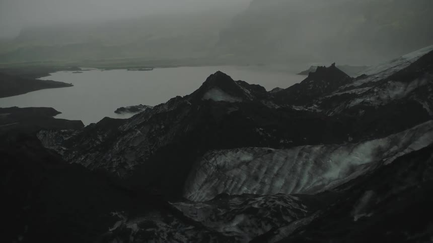 An aerial view of a mountain range with a body of water at the bottom