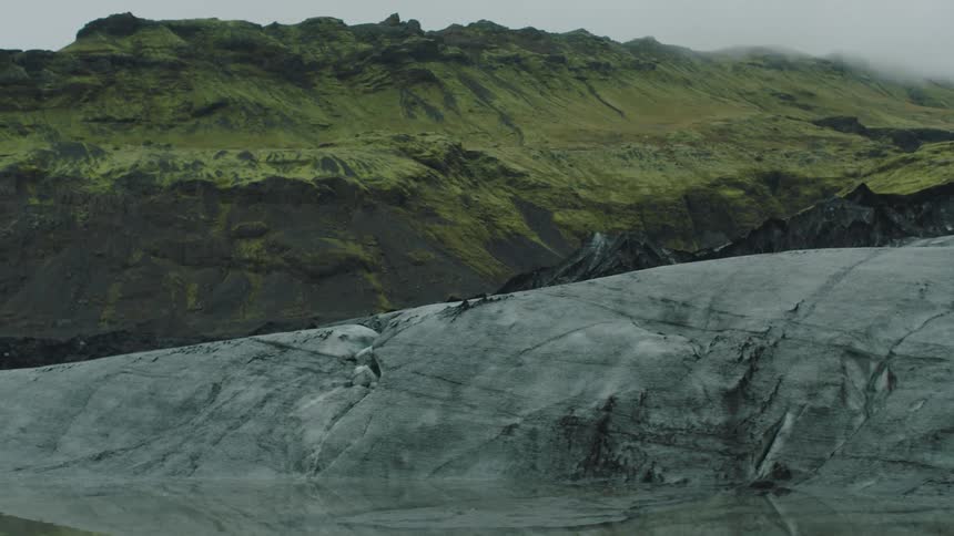 Green mountains on the highlands next to the smooth gray rock hills