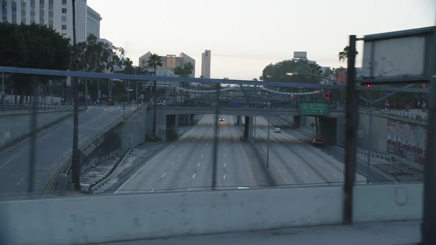 A pair of bridges over a freeway through a metropolis during the day