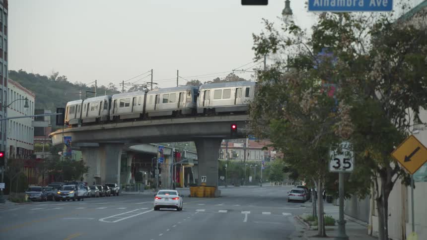 Cars are driving on a road through a city