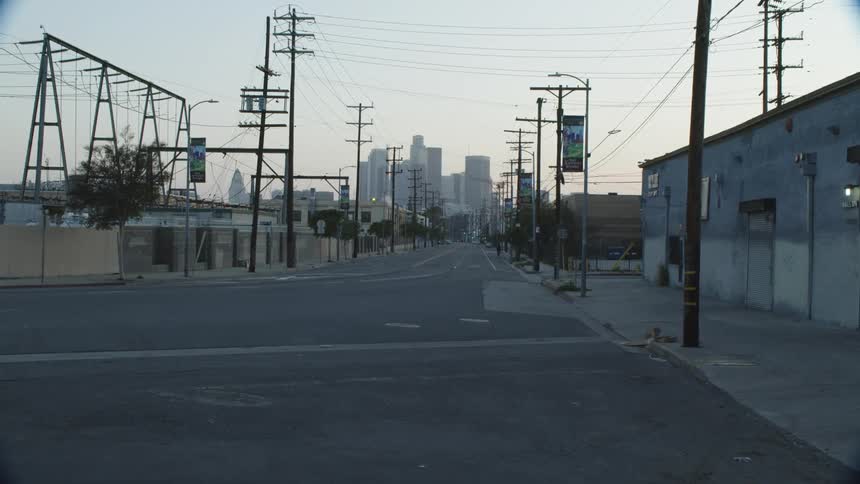 A city street with buildings utility poles the sky and clouds in the background
