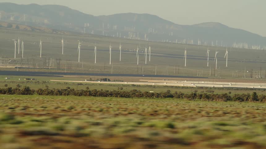 Wind turbines in a field with mountains in the background
