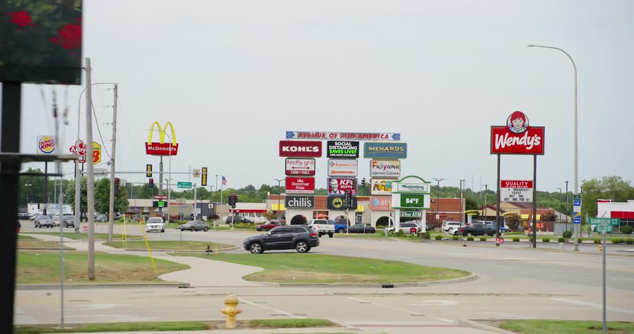 A shot of a strip malls with many store logos and signs