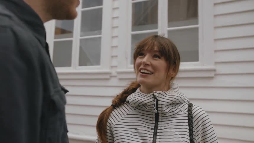 A woman talks to a man standing next to here