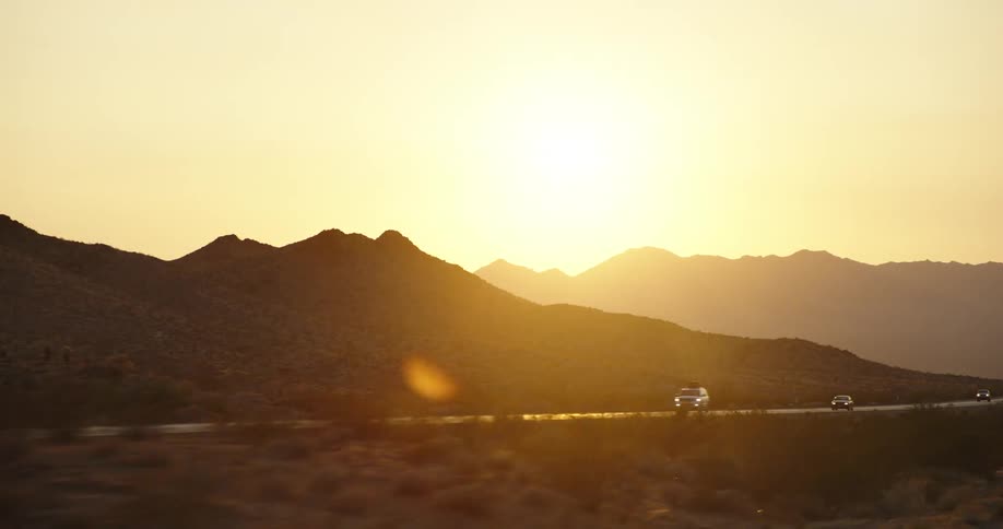 Cars are driving on a road at dusk