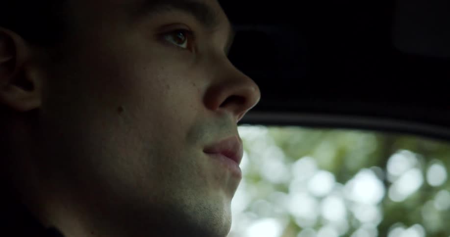 A man searches his surroundings as he drives a vehicle