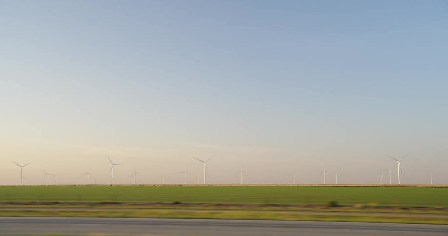 Wind turbines on a wind farm in the green fields on a rural area at evening