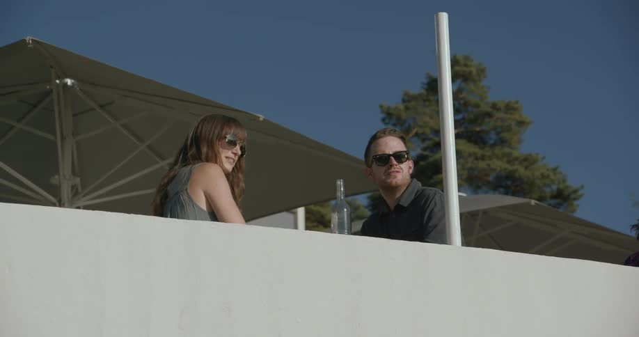 A man and woman seated outdoors look out at the scenery