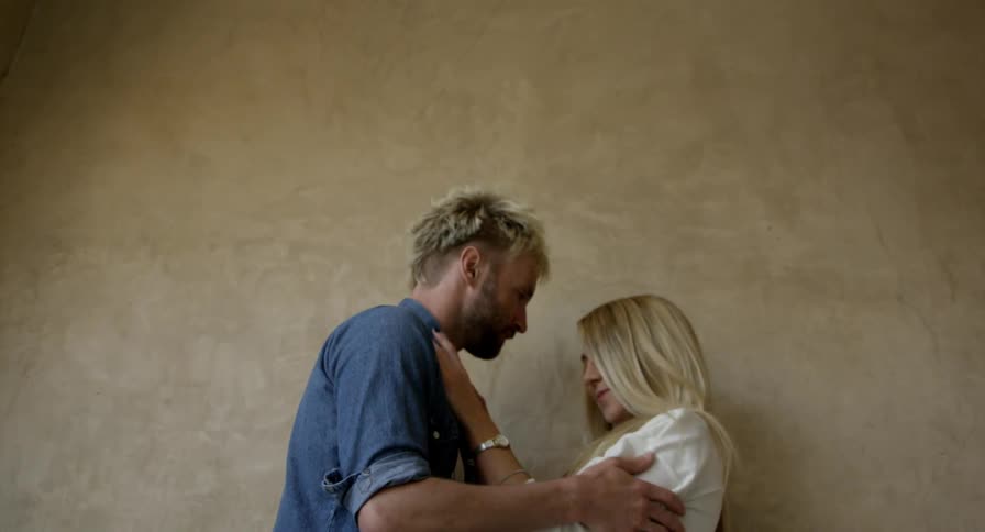 A man and woman hold rub their arms over one another and laugh
