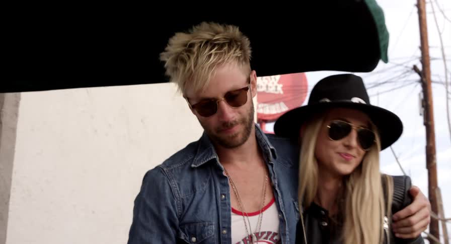A male and female caucasian couple with blonde hair walking arm and arm