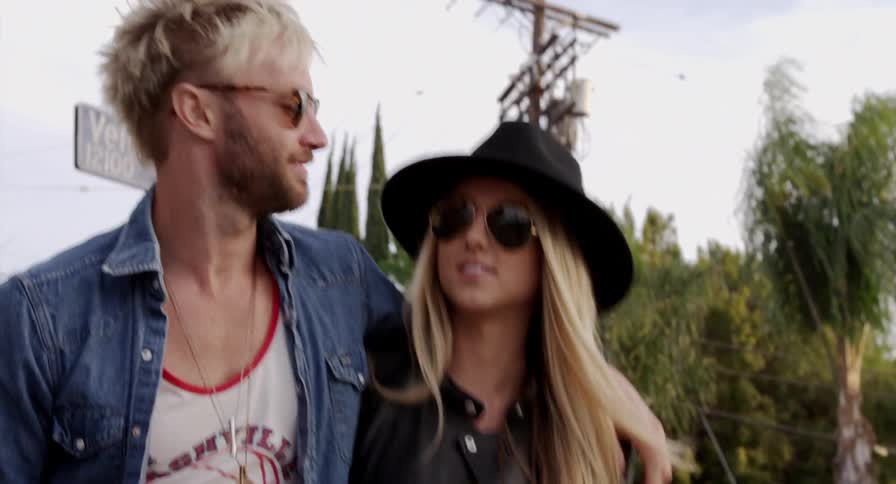 A man and woman walking outside with their arms around one another