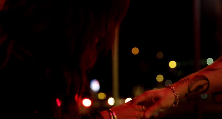 A man and woman are standing outdoors at night together
