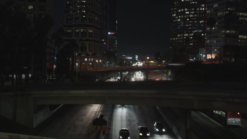A panning shot of a highway in a city during the night