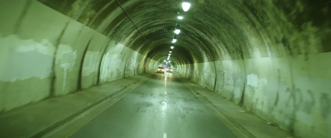 Twisting footage of cars driving inside a small tunnel