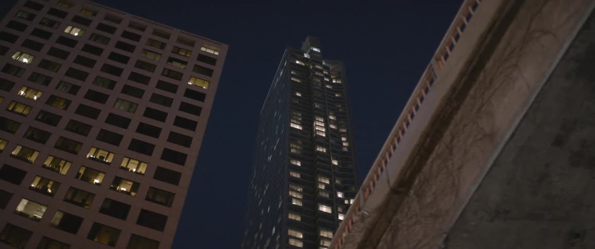 A wide shot of a skyscraper at night