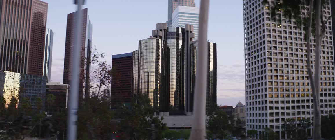 Vehicle driving down a city street in front of office buildings