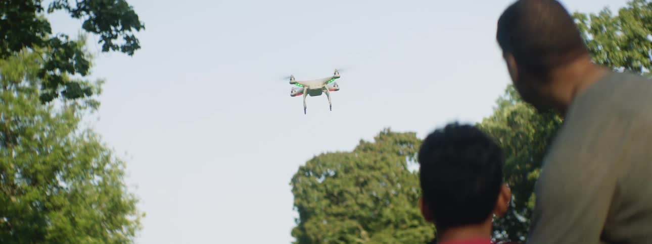 A father and son fly a drone together
