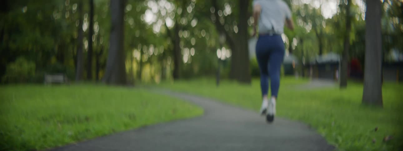 A woman runs down a path in a public park